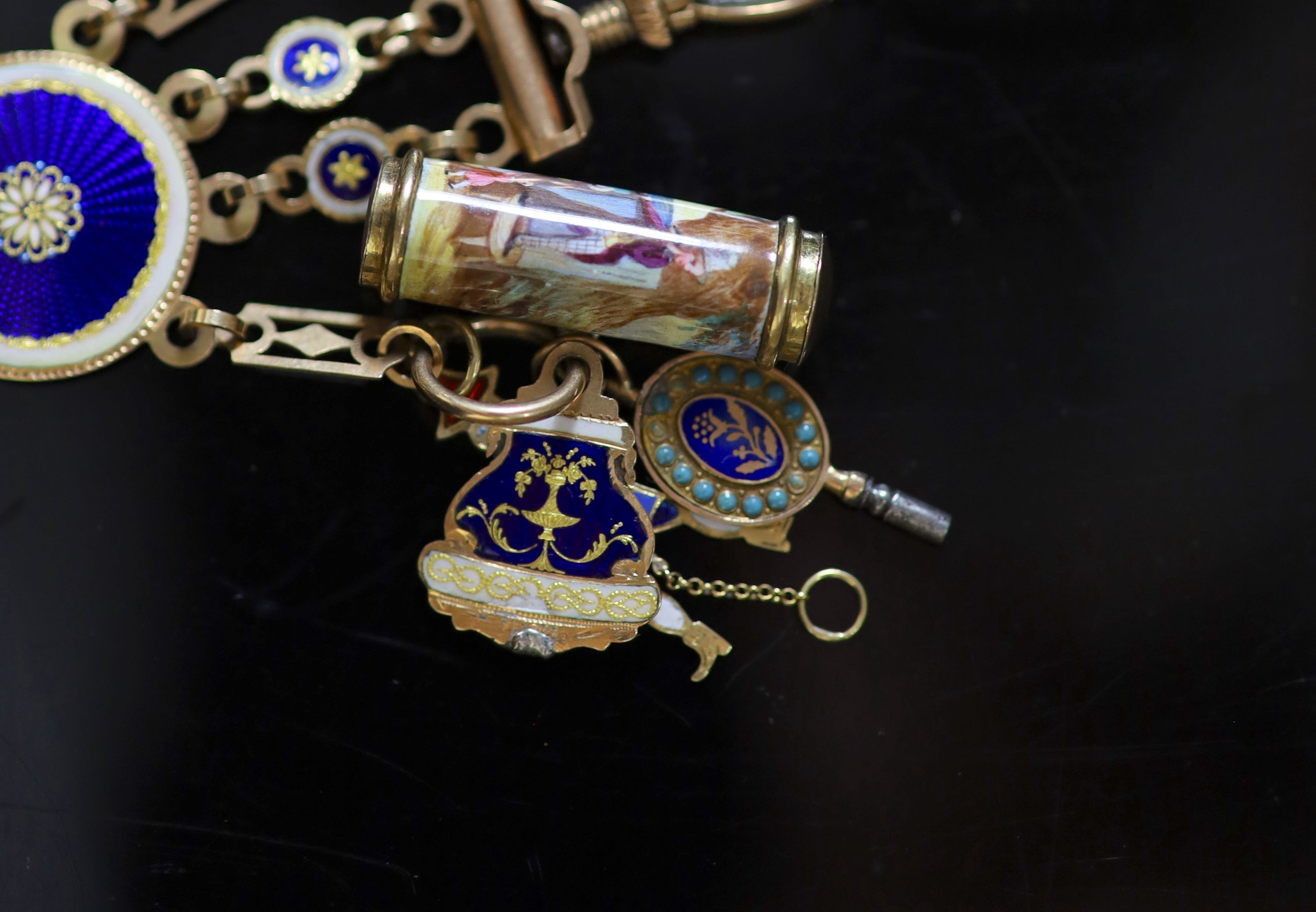 An early 19th century French or Swiss gold and enamel chatelaine, hung with eleven assorted accoutrements